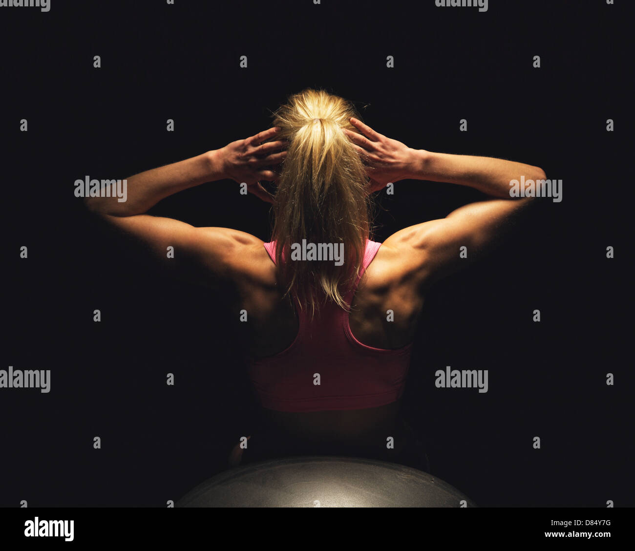 Femme Fitness faisant des craquements d'estomac tout en étant allongé sur le yoga ball Banque D'Images
