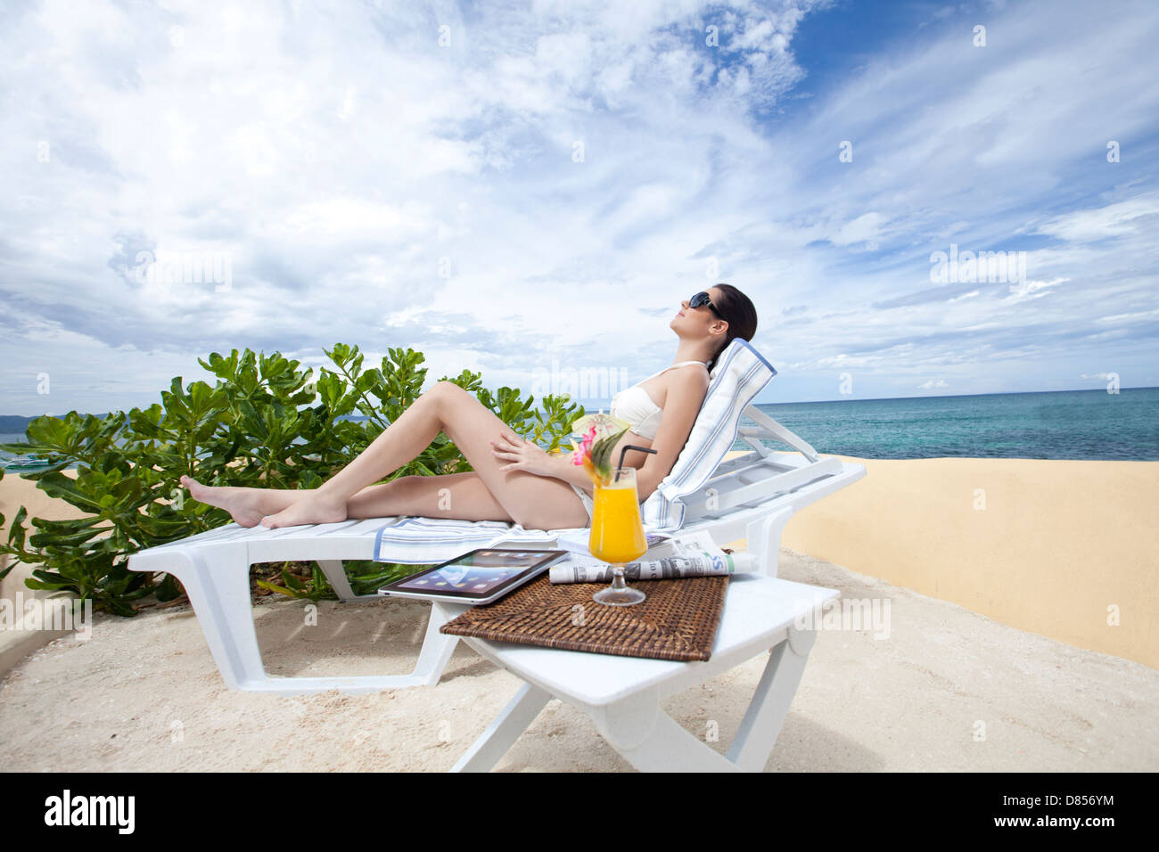 Jeune femme au soleil dans une chaise océan. Banque D'Images