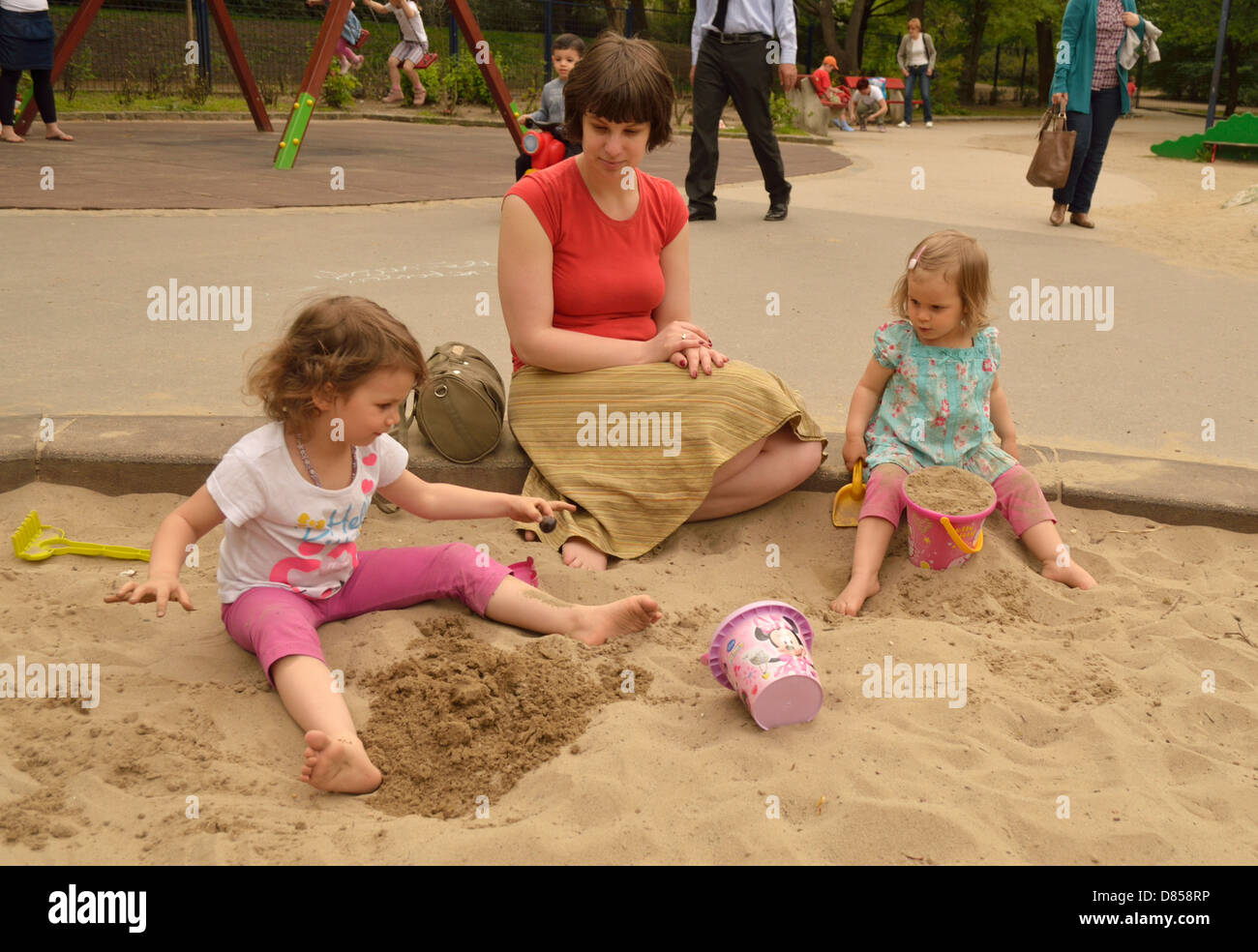2 et 4 ans, les petites filles avec la mère dans la fosse de sable jouets aire de jeu Banque D'Images