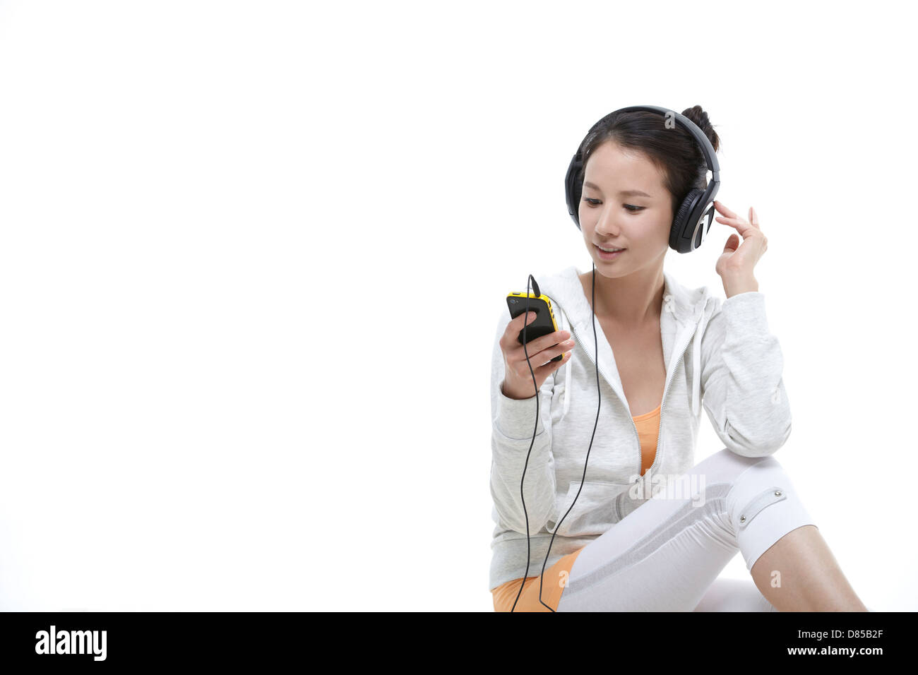 Jeune femme assise à écouter de la musique. Banque D'Images