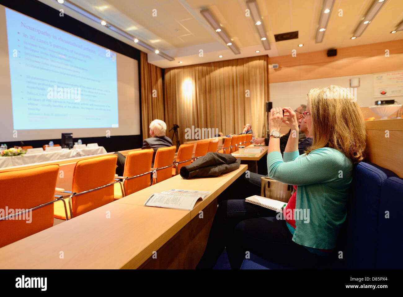 Femme à prendre des photos avec son téléphone mobile pendant une présentation de conférence Banque D'Images