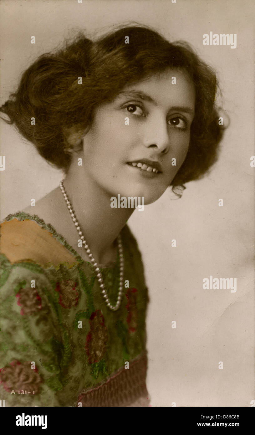 Jeune femme en robe verte et collier de perles Banque D'Images