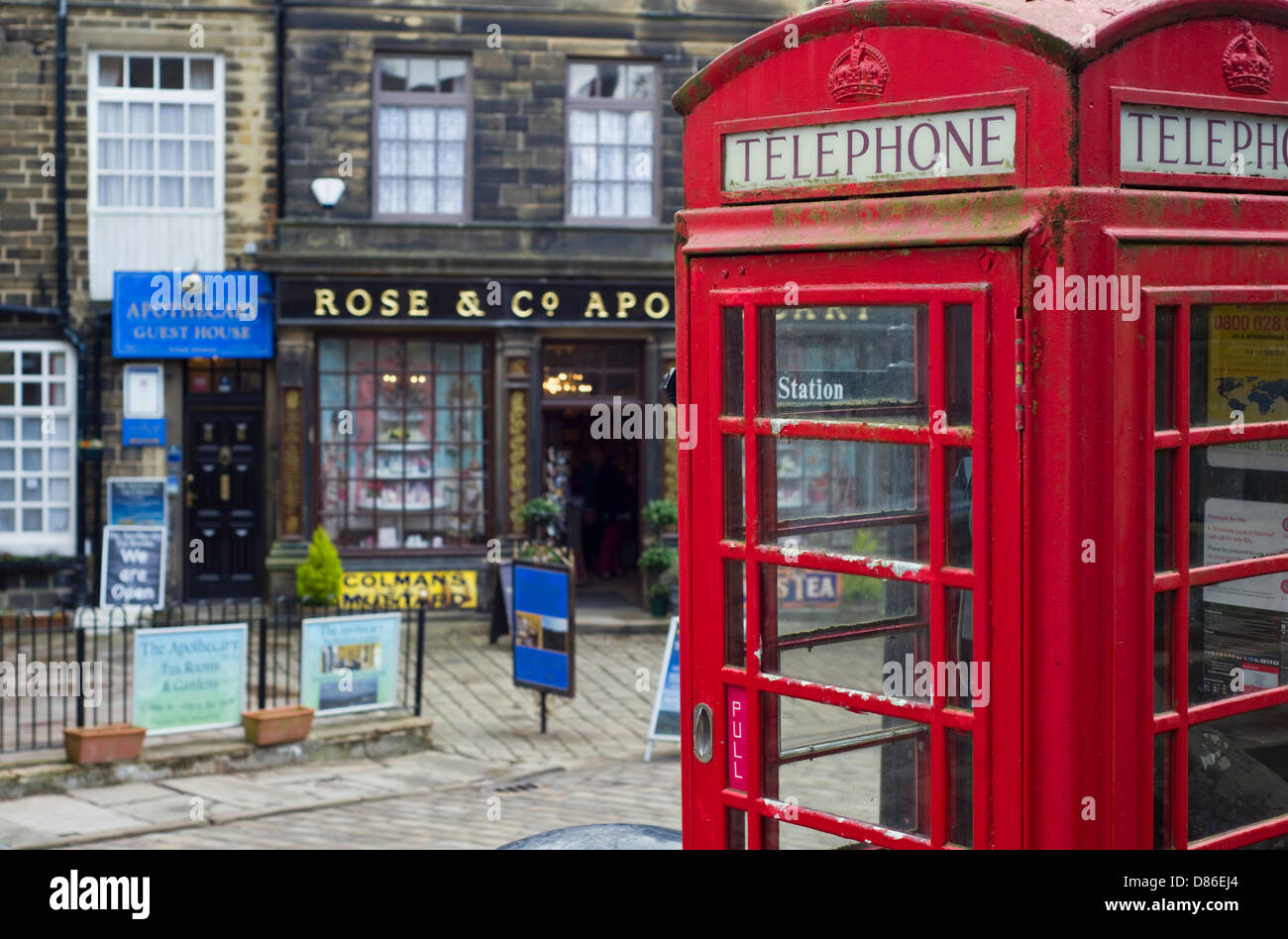 Boîte de téléphone rouge sur la rue principale à travers le village de Haworth dans le West Yorkshire, England, UK Banque D'Images