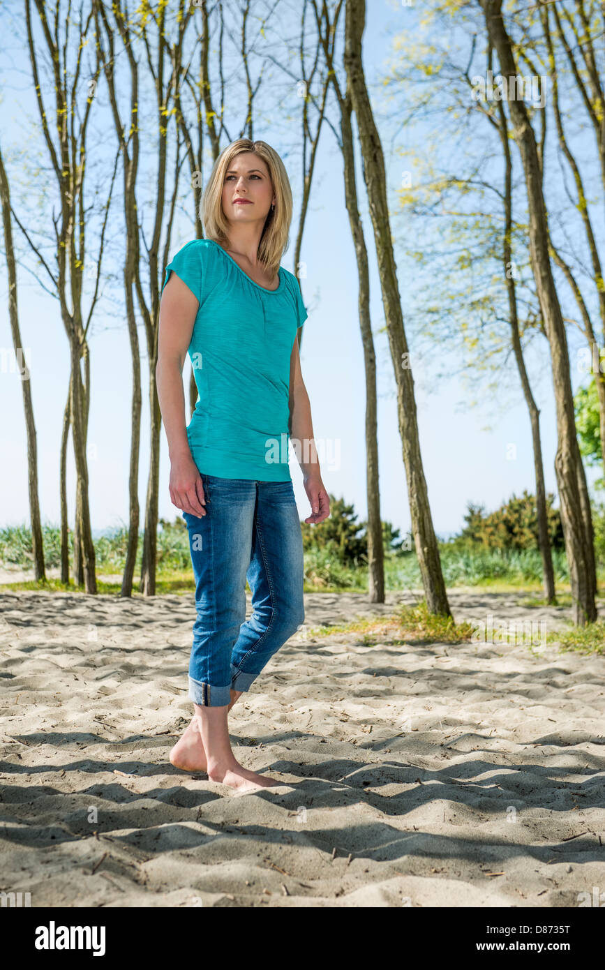 Toute la longueur de belle jeune femme à la voiture tandis que standing on beach Banque D'Images