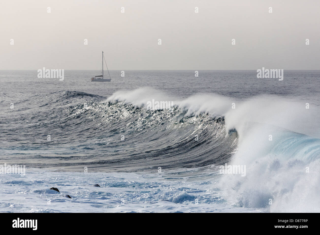 L'Espagne, la rupture de vagues, bateau à voile en arrière-plan à La Gomera Banque D'Images