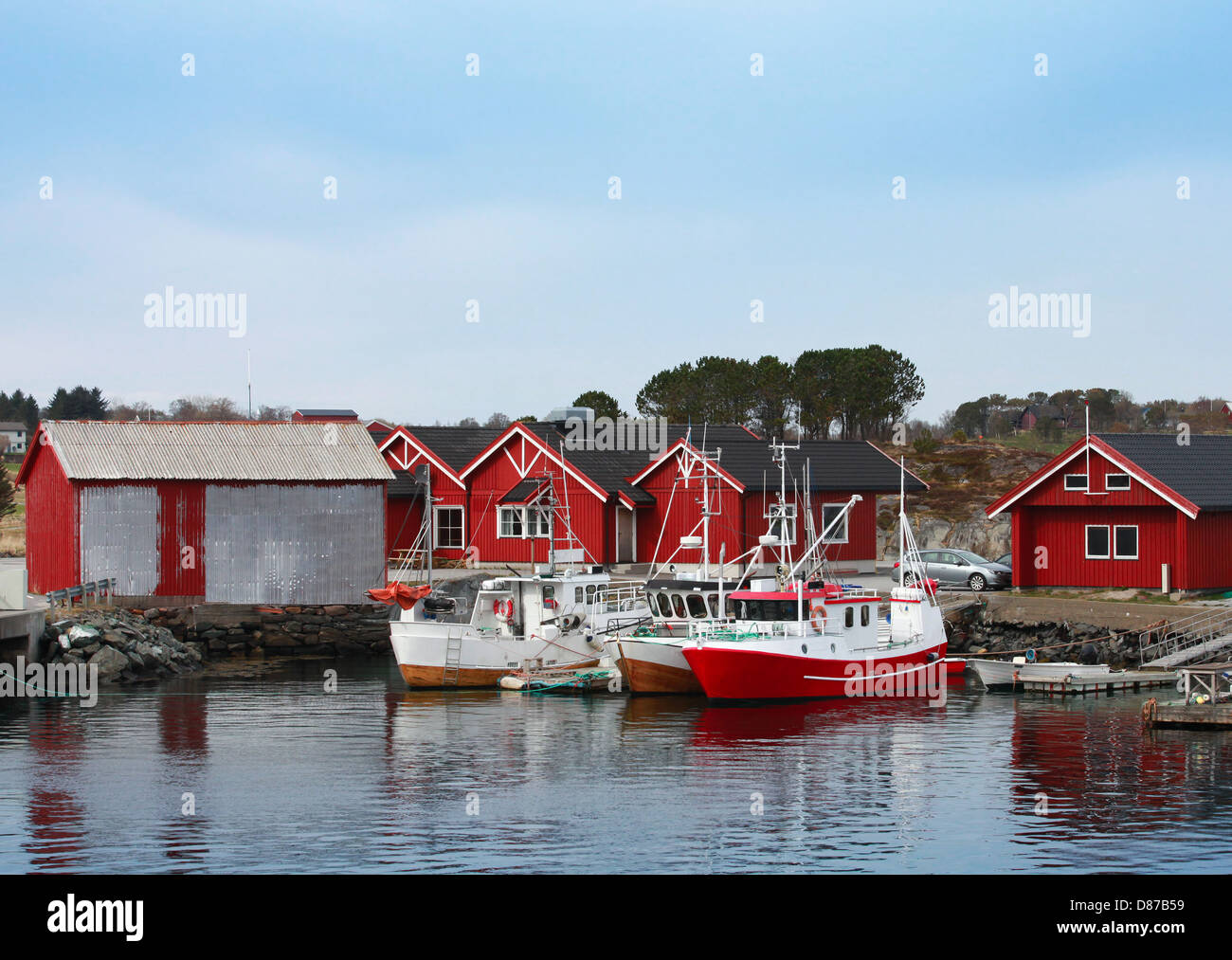 Village de pêcheurs norvégiens avec maisons en bois rouge et des petits bateaux sur la côte de la mer Banque D'Images