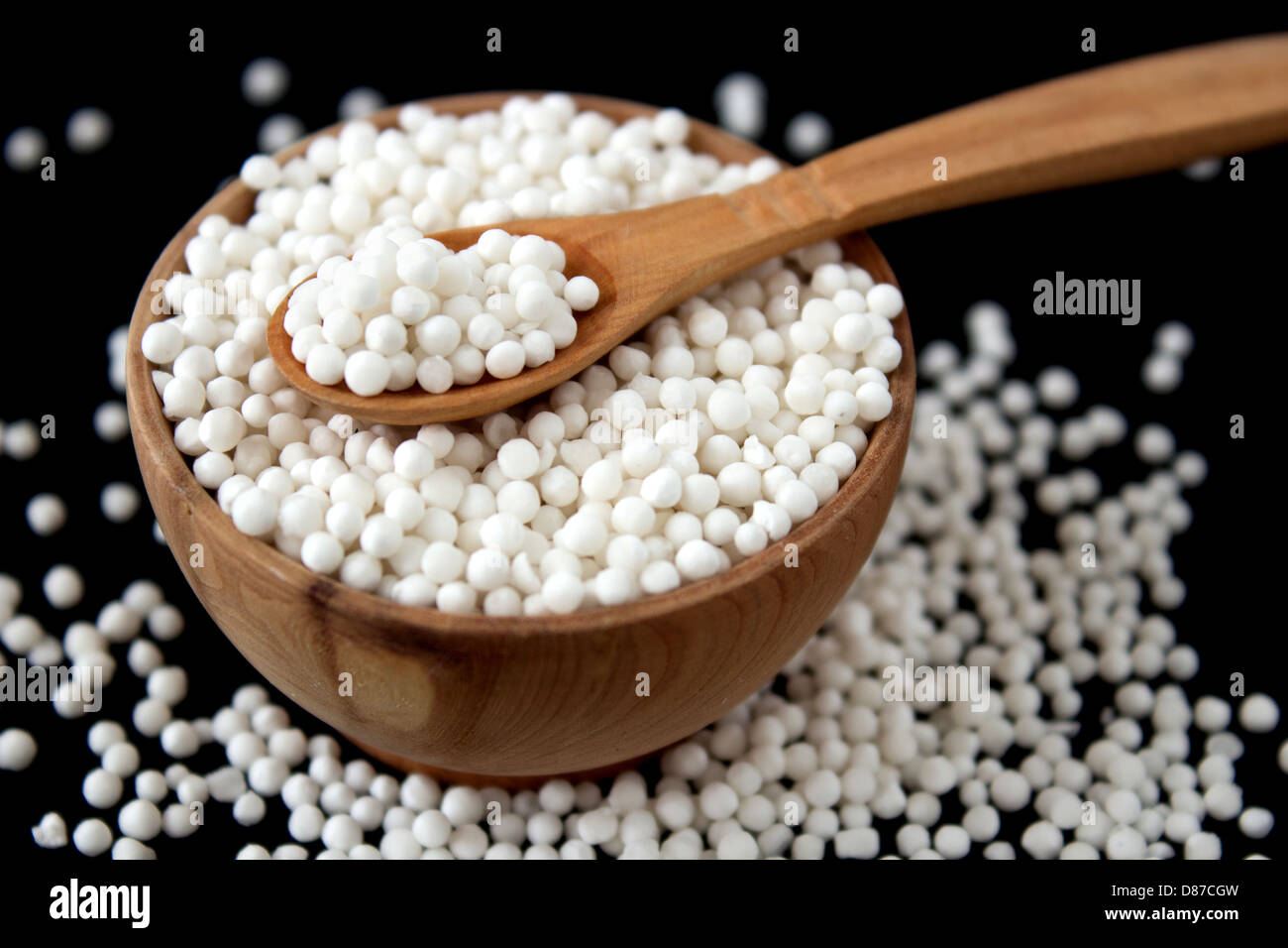 Perles de tapioca en petit bois bol sur fond noir Banque D'Images