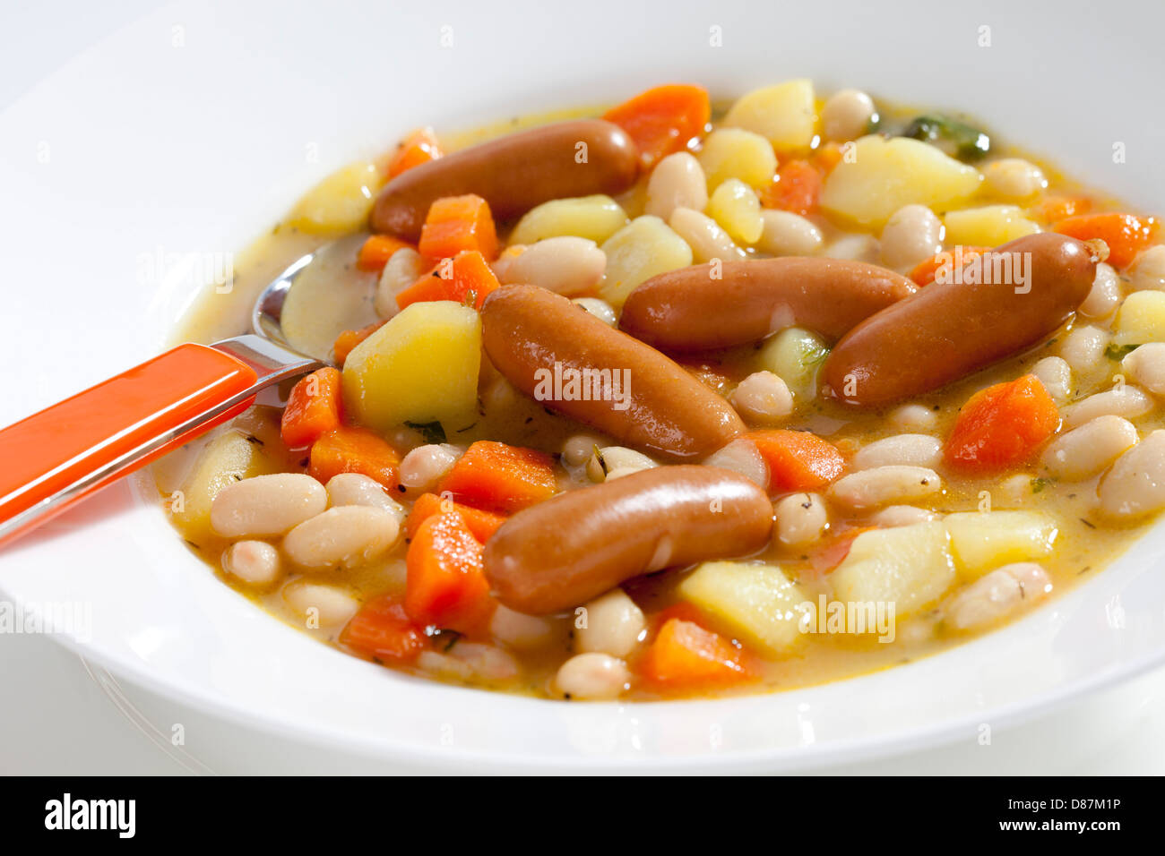 Bol de soupe de haricots avec carottes, pommes de terre et mini-saucisses, Close up Banque D'Images