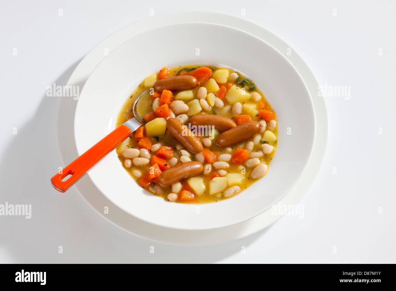 Bol de soupe de haricots avec carottes, pommes de terre et mini saucissons Banque D'Images