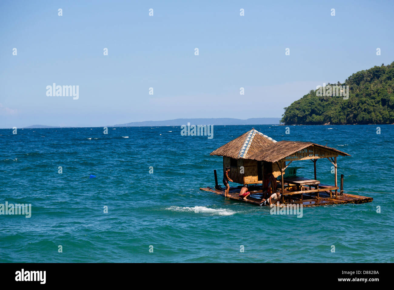 Les enfants d'un saut d'une maison flottante dans l'océan sur l'île de Mindoro, Philippines Banque D'Images