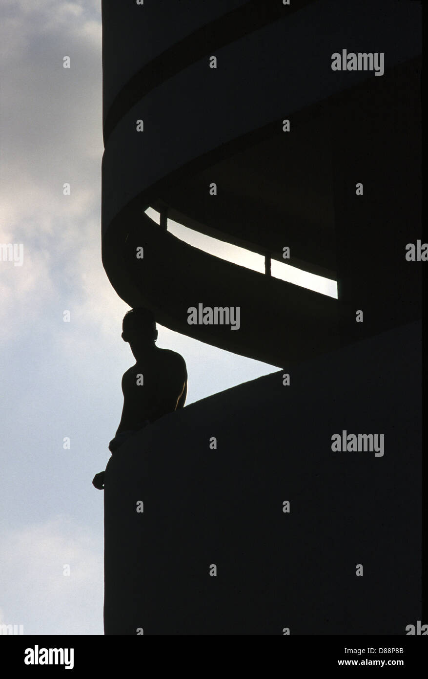 Un homme debout dans un style Bauhaus en balcon Dizingof Square centre-ville de Tel Aviv, Israël. Tel Aviv est un site classé au Patrimoine Mondial pour son architecture unique, le plus grand montant de 'International' des bâtiments de style Bauhaus dans le monde (4000). Banque D'Images
