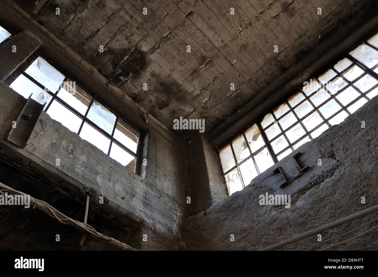Broken windows mur de béton et de plafond en usine à l'abandon. L'architecture industrielle. Banque D'Images