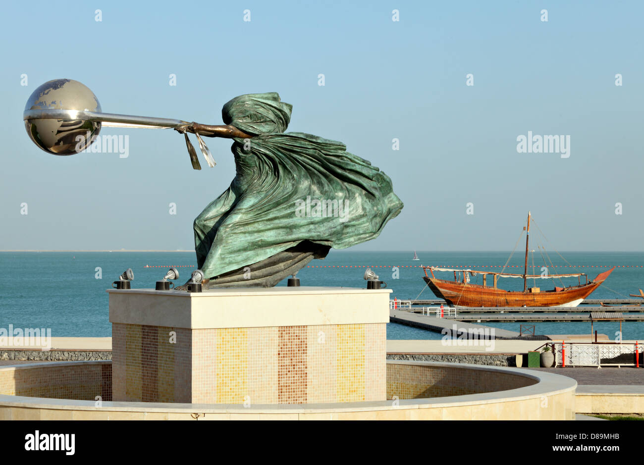 La force de la nature II par Lorenzo Quinn, exposée au village du patrimoine de Katara, Doha, Qatar, avec un boutre arabe derrière elle Banque D'Images