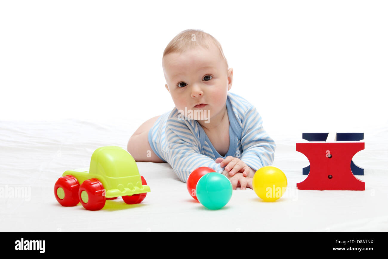 Beau bébé jouer avec ses jouets sur blanc Banque D'Images