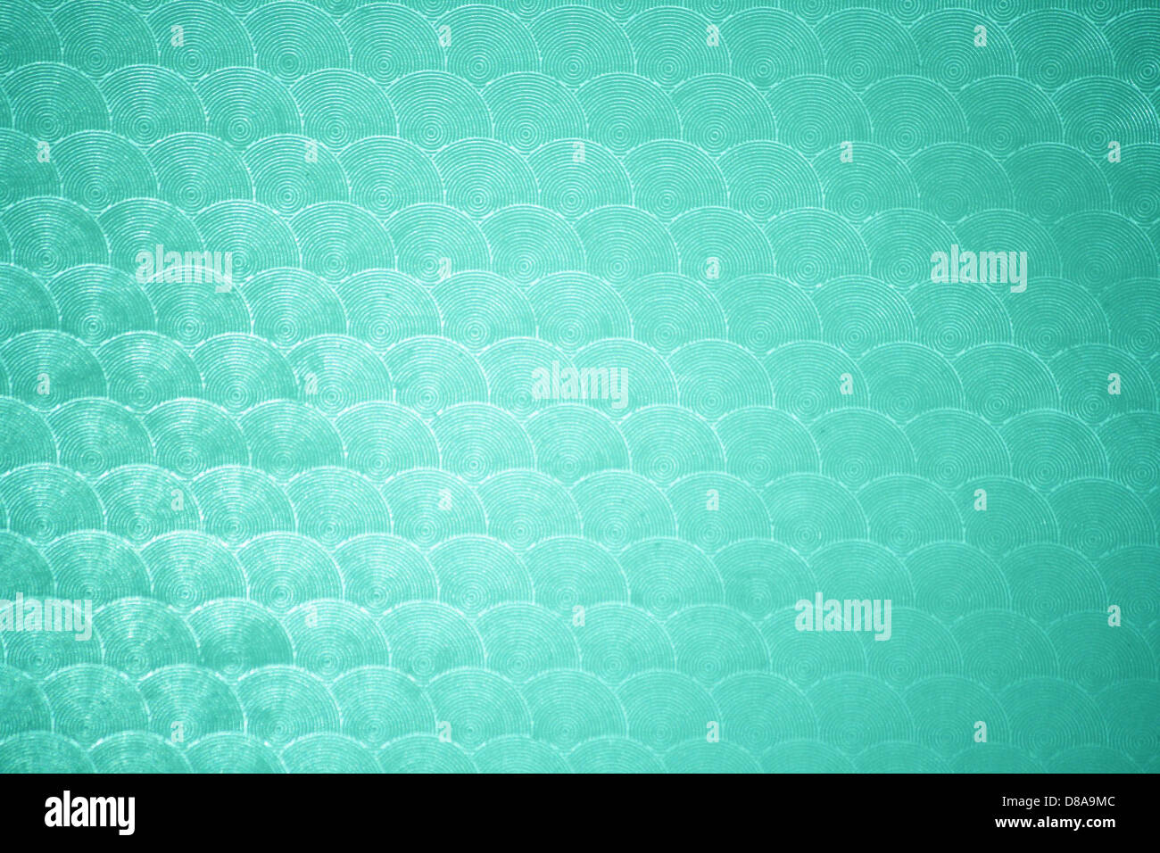 Un gros plan de plastique vert aqua avec un motif circulaire sur sa surface. La couleur douce et fraîche et le motif répétitif donnent au matériau un aspect distinct, adapté à la conception et à la décoration. Banque D'Images