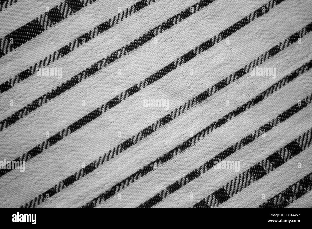 Tissu orné de rayures diagonales noires et blanches, pour un design audacieux et contrasté. La texture rayée ajoute un look moderne et graphique au textile. Banque D'Images
