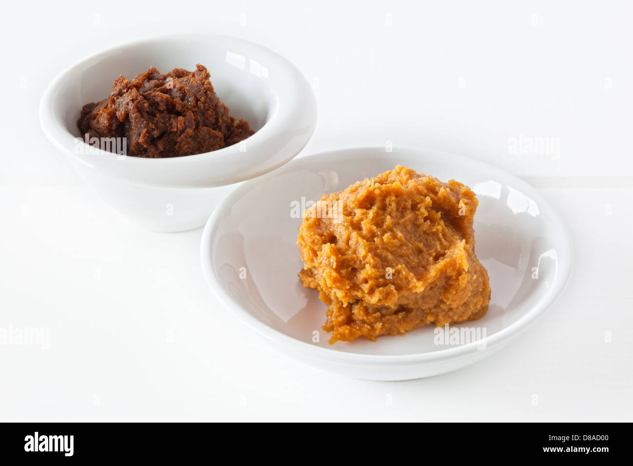 La pâte de miso - Pâte de miso rouge et jaune dans les bols blancs sur fond blanc. Banque D'Images
