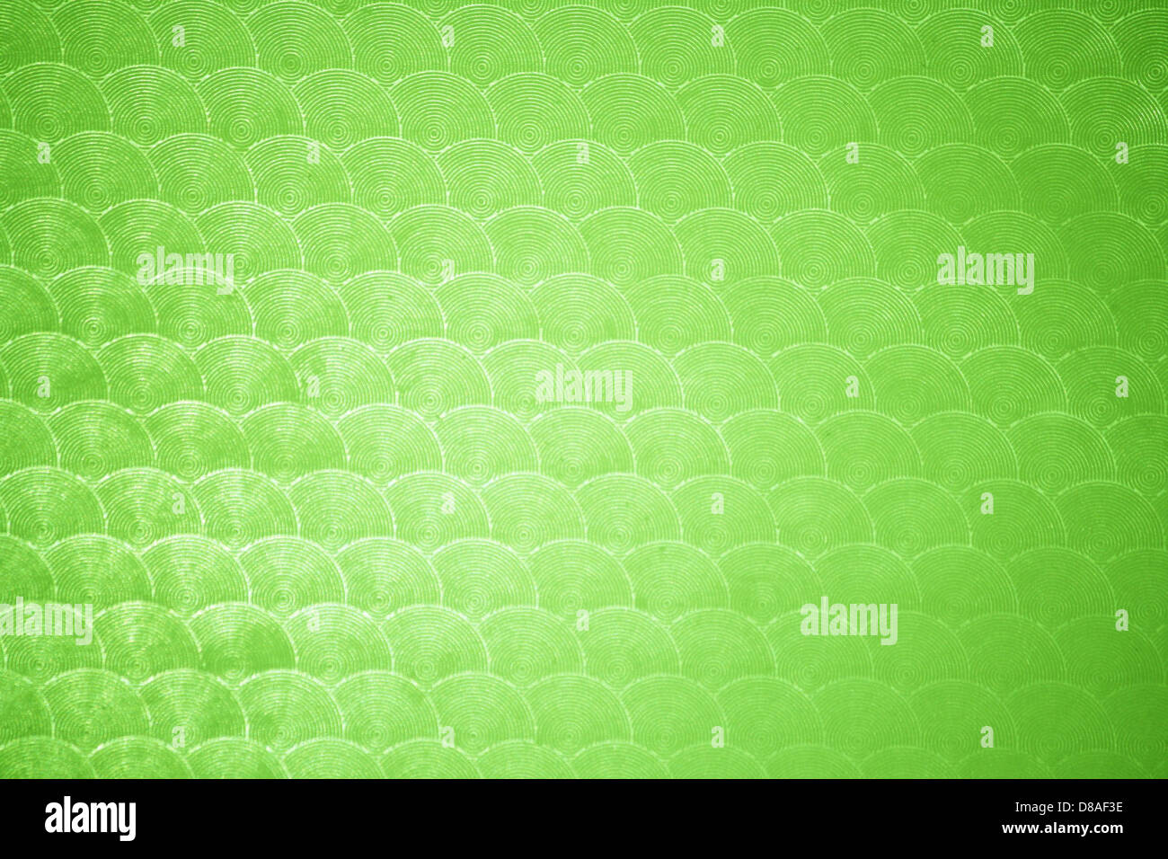 Gros plan de plastique vert citron avec un motif circulaire. La texture lisse et la couleur vibrante en font un matériau unique souvent utilisé dans la conception et la fabrication de produits. Banque D'Images