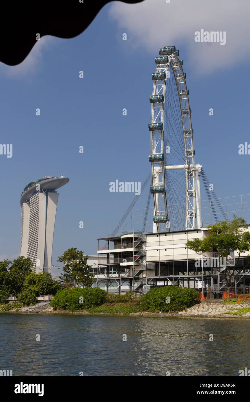 Le Singapore Flyer, le Marina Bay Sands et bâtiments temporaires sur le rivage de l'eau. Construction pour la Formule Un en cours. Banque D'Images