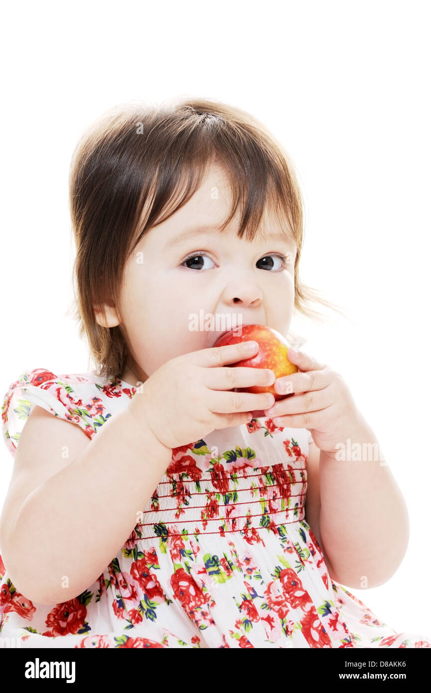 Petite fille en prenant une bouchée de pomme rouge closeup portrait Banque D'Images