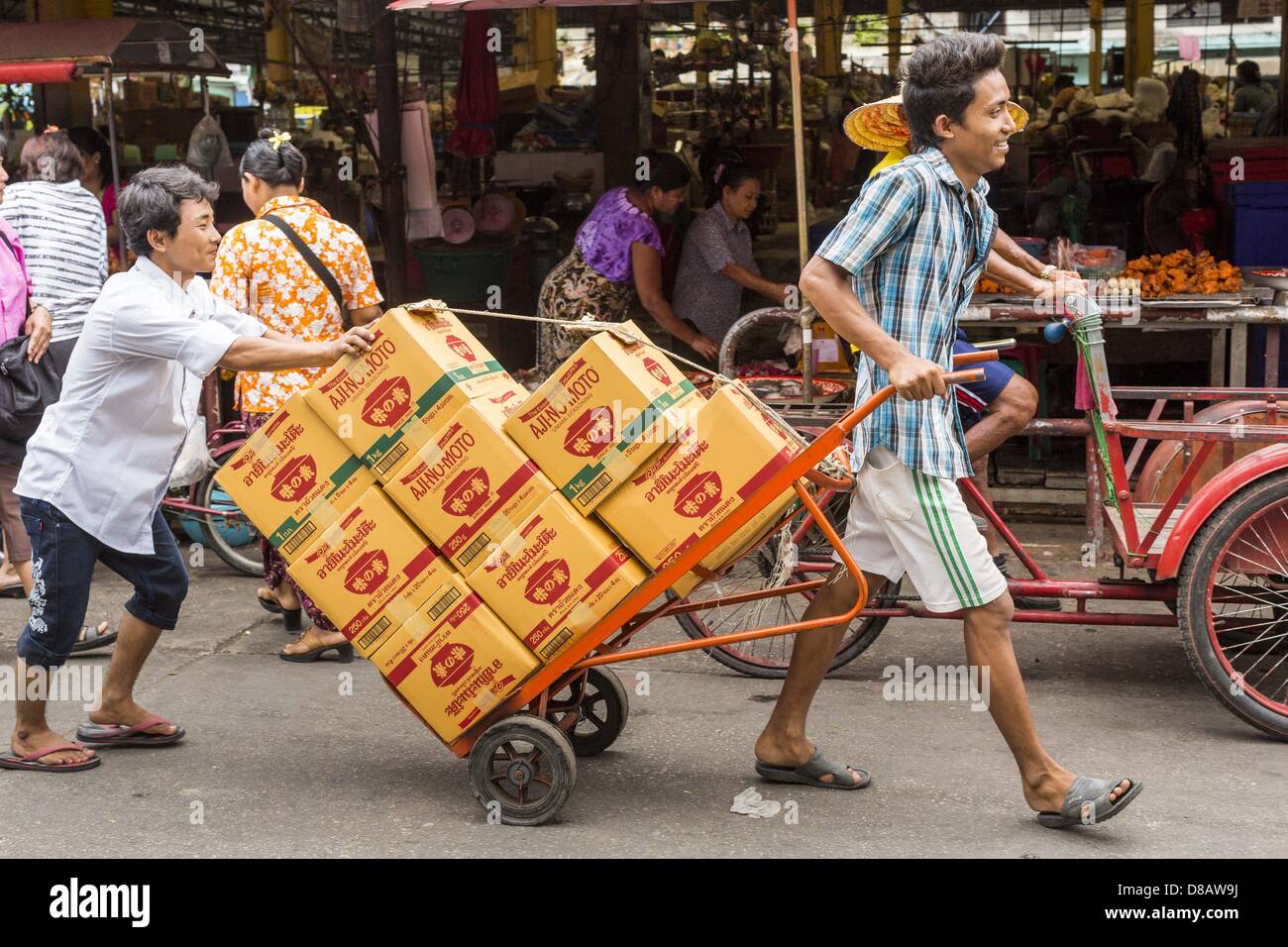 23 mai 2013 - Mae Sot, Tak, Thaïlande - porteurs birmans faire une livraison au marché Birman à Mae Sot, en Thaïlande. Cinquante années de troubles politiques en Birmanie (Myanmar) a conduit des millions de Birmans à quitter leur pays. Beaucoup se sont installés en Thaïlande voisine. Mae Sot, sur le Mae Nam (rivière) Veldzes Nams Veldzes Nams est le centre de la communauté birmane dans Central Western emigre en Thaïlande. Il y a des centaines de milliers de réfugiés birmans et les migrants dans la région. Beaucoup vivent une existence d'ombre sans papiers et sans recours s'ils traversent les autorités thaïlandaises. Les Birmans ont leurs propres écoles et hôpitaux Banque D'Images