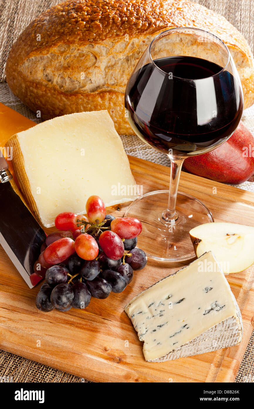 Le vin rouge et le plateau de fromages assortis aux fruits Banque D'Images