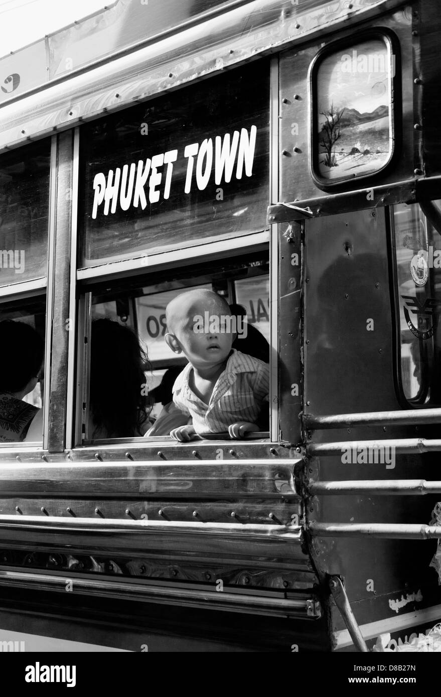 PHUKET, Thaïlande 6 SEPTEMBRE 2011 : Un garçon attend un bus public à partir Banque D'Images