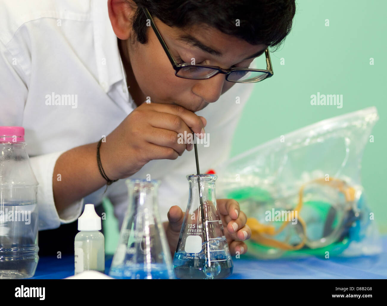 Homme high school student of middle eastern décents, utilise la science au cours de bécher démonstration juste Banque D'Images