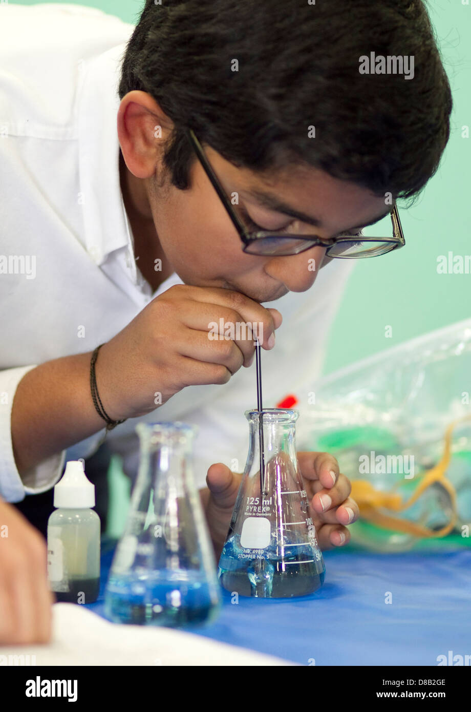 Homme high school student of middle eastern décents, utilise la science au cours de bécher démonstration juste Banque D'Images