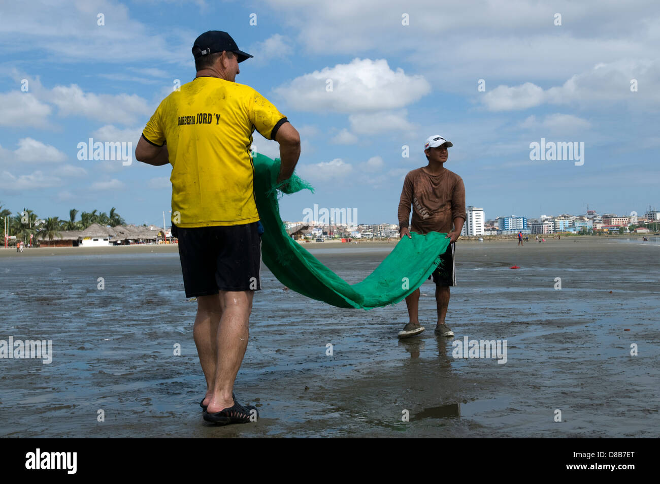 Deux hommes du bobinage de Manabi un filet de pêche sur la plage de Tarqui Banque D'Images