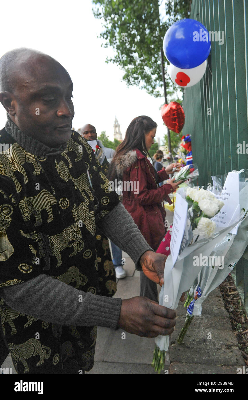 Woolwich, Londres, Royaume-Uni. 23 mai 2013. Un groupe de Nigérians de Shepherds Circulation laisser fleurs sur les grilles sur les lieux du crime à Woolwich. Les fleurs sont laissés par les bienfaiteurs le long des rampes près de l'endroit où le batteur Lee Rigby du 2e Bataillon du Régiment royal de fusiliers a été tué hier à l'extérieur des casernes de Woolwich. Crédit : Matthieu Chattle/Alamy Live News Banque D'Images