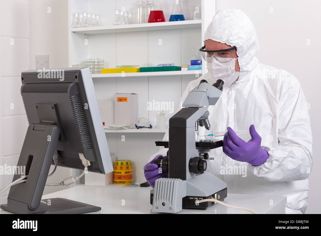 Un technicien de laboratoire à la recherche à l'image du microscope sur un écran Banque D'Images