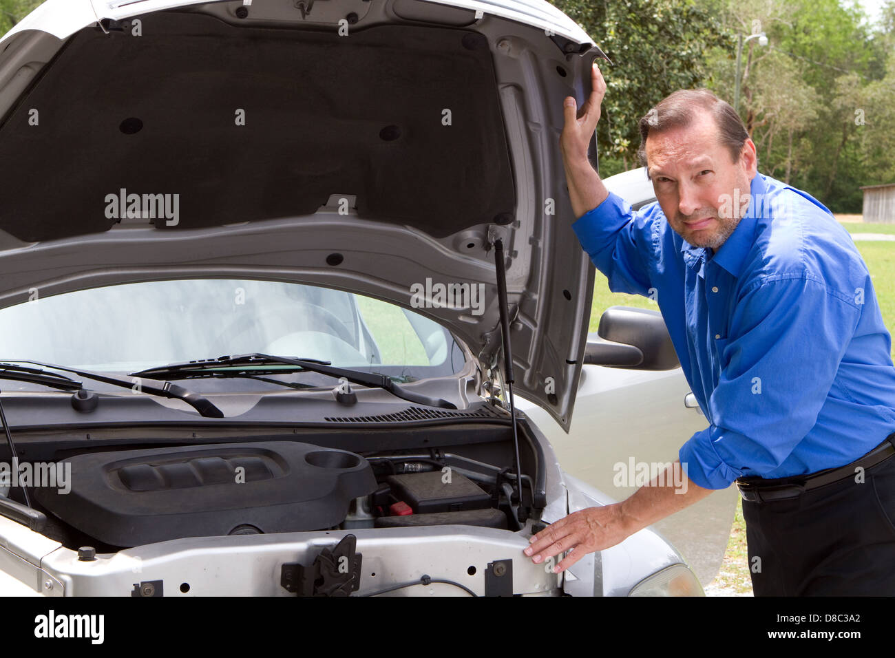 Senior homme avec un air de consternation sur son visage alors qu'il se distingue par sa mobilité voiture qui a besoin de réparation. Banque D'Images