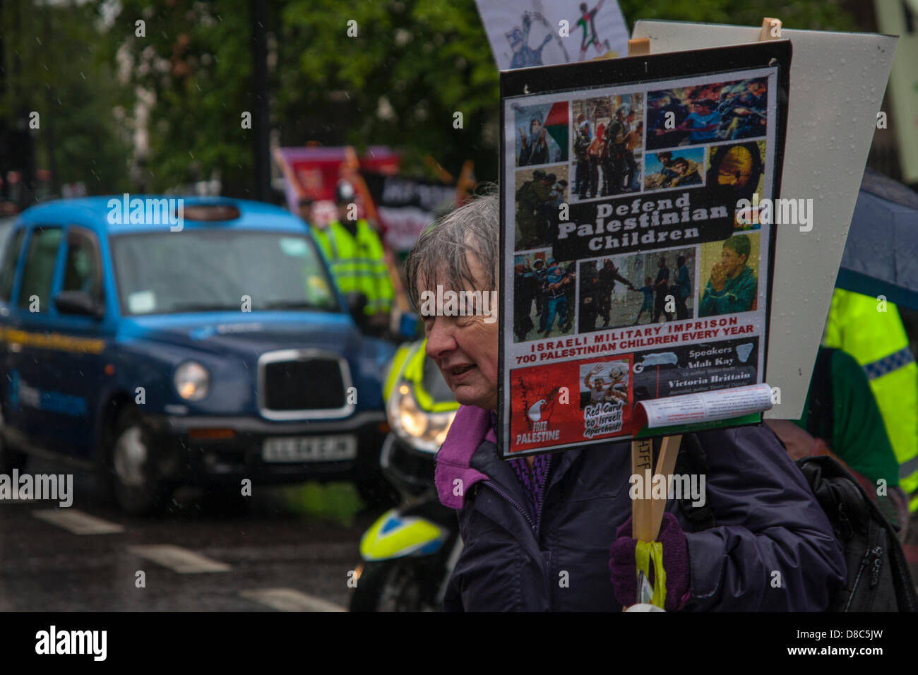 Londres, Royaume-Uni. 24 mai 2013 baignée par la pluie. Un militant pro-palestinien arrive à la manifestation à l'extérieur de l'hôtel Grosvenor House en tant que délégués de l'UEFA pour répondre à leur congrès annuel. Crédit : Paul Davey / Alamy Live News Banque D'Images