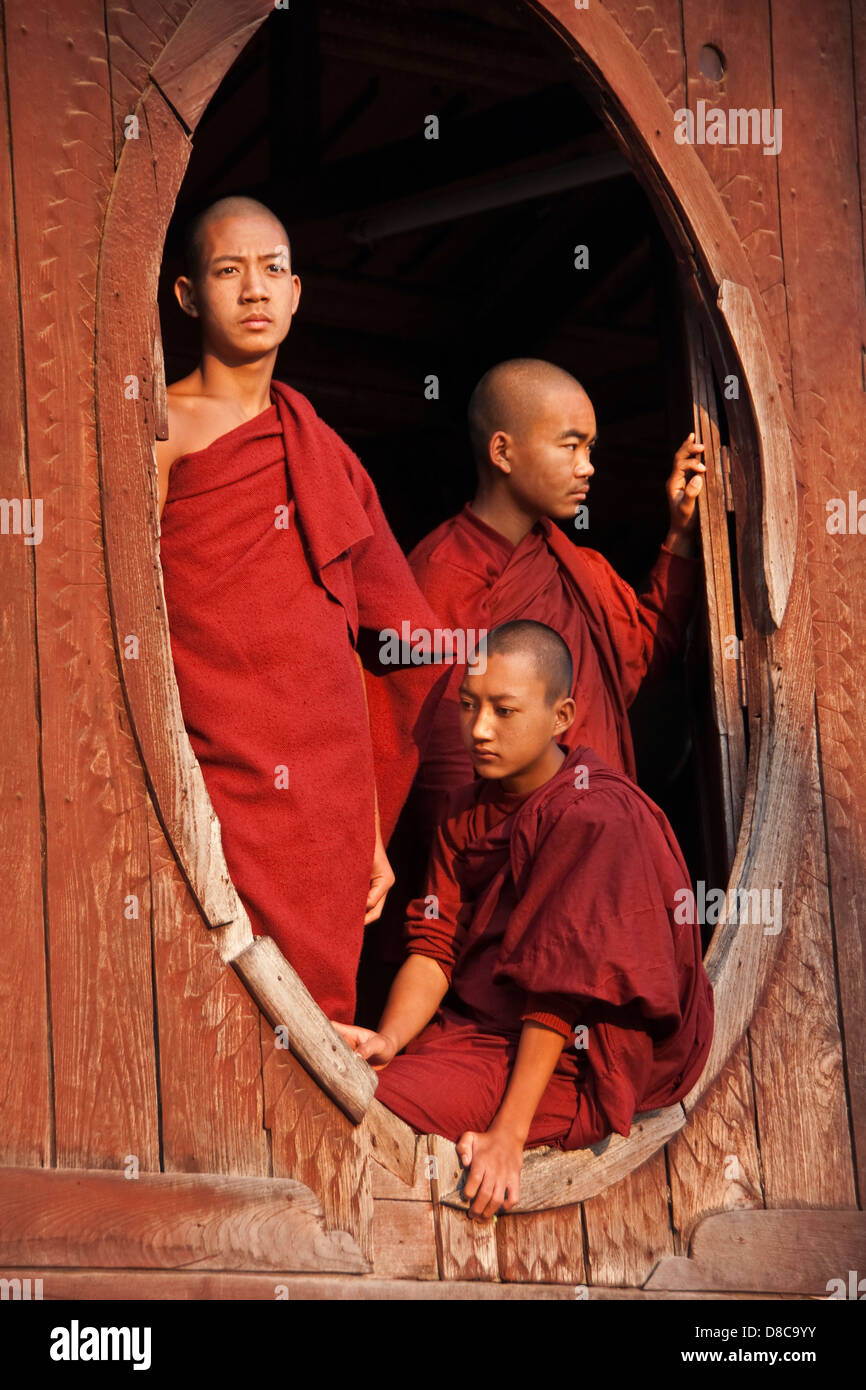 Les moines novices dans la fenêtre du monastère près du lac Inle dans l'Etat Shan, Myanmar. Banque D'Images