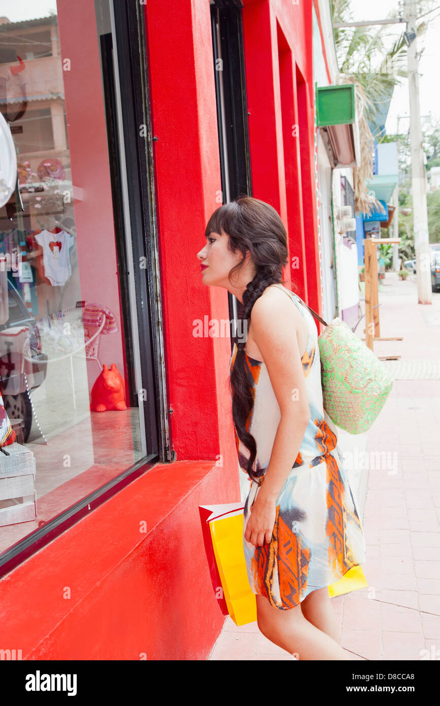 Femme à la fenêtre boutique en Banque D'Images