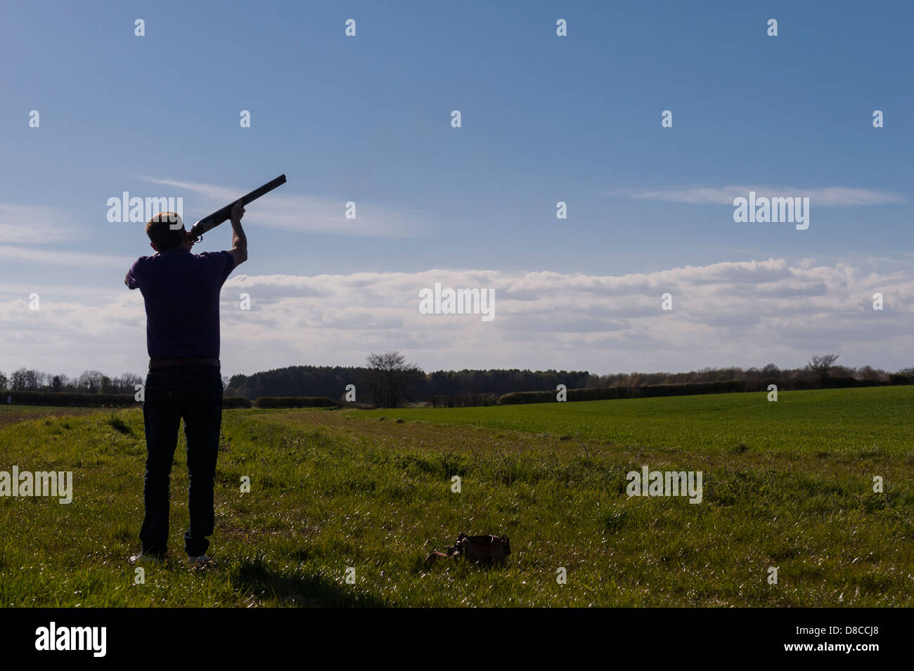 La silhouette d'un tir aux pigeons d'argile de l'homme avec un fusil au Royaume-Uni Banque D'Images