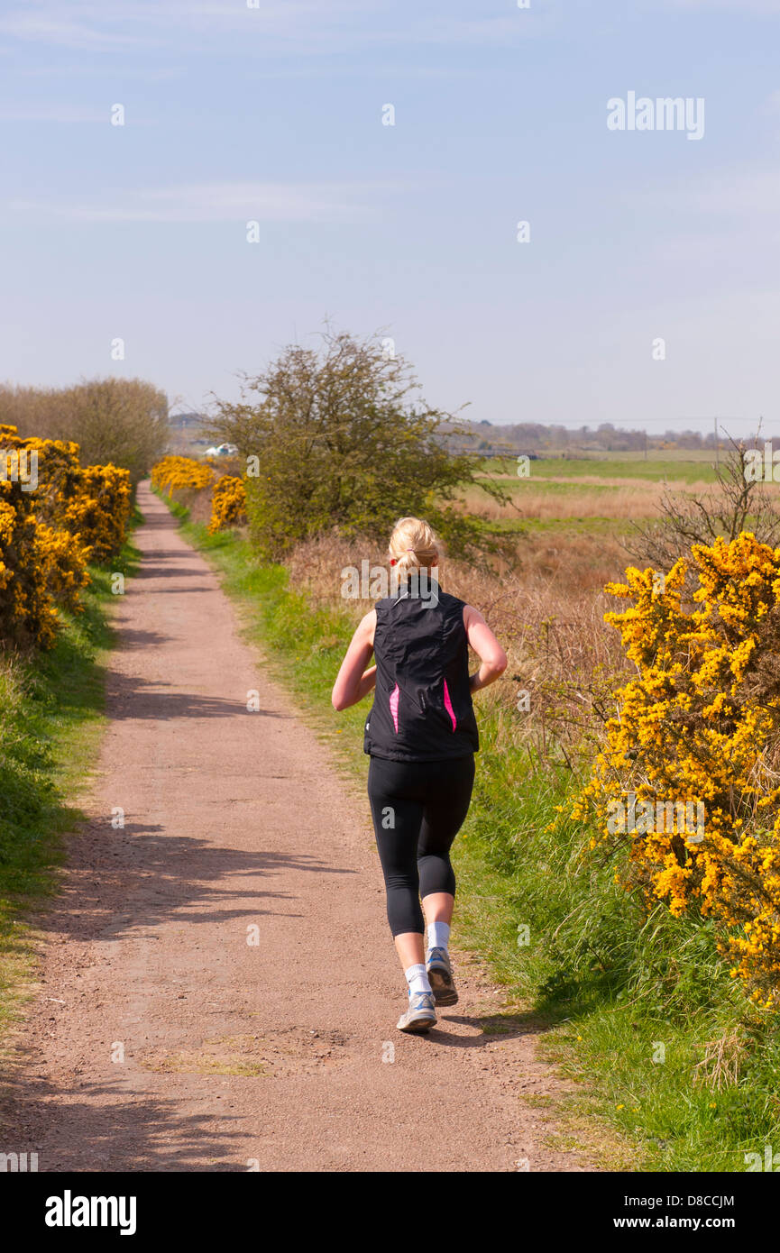 Une femme d'un pays bas de jogging path à Southwold , Suffolk , Angleterre , Angleterre , Royaume-Uni Banque D'Images