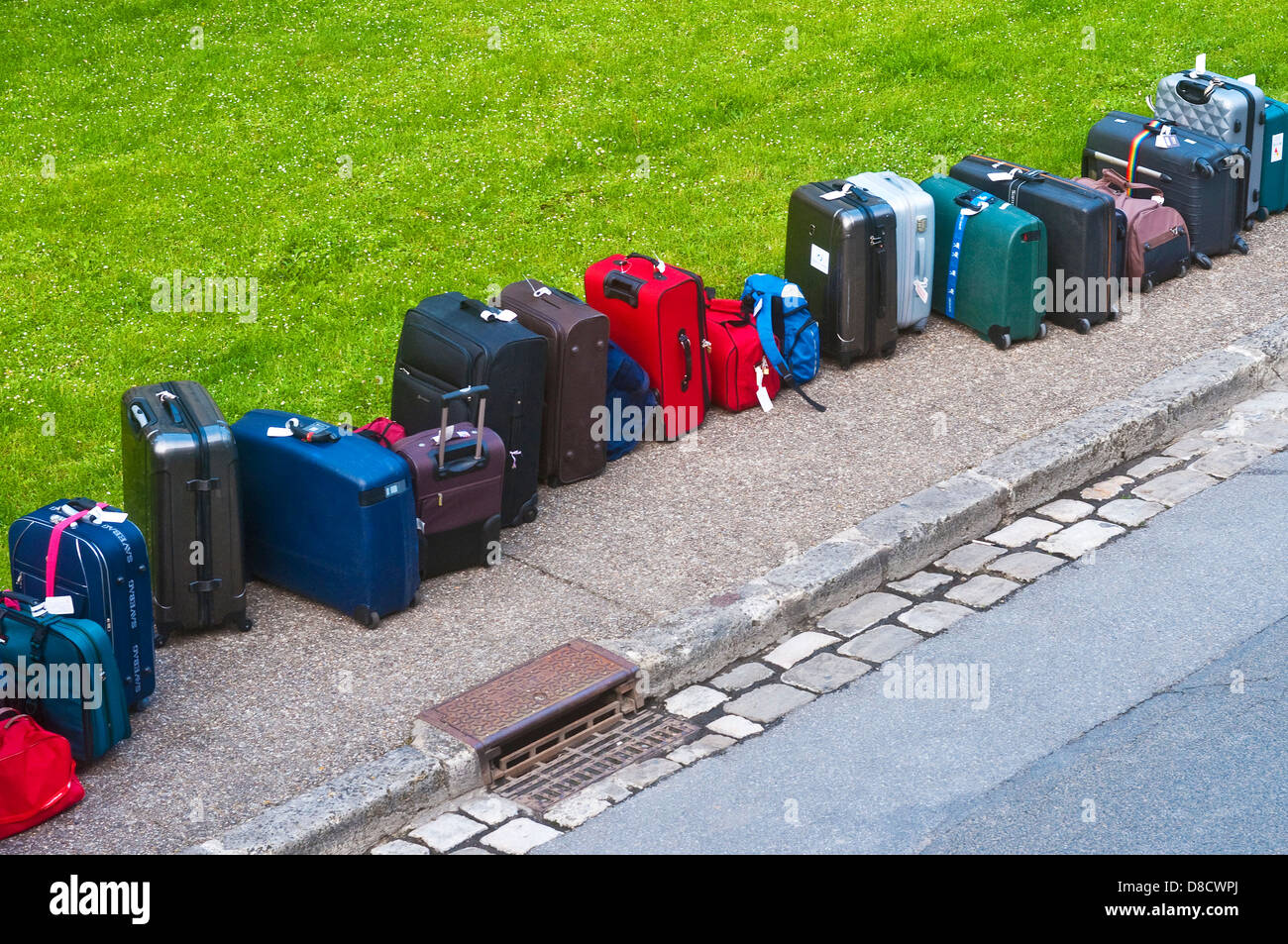 Longue ligne de valises sur trottoir du touriste - France. Banque D'Images