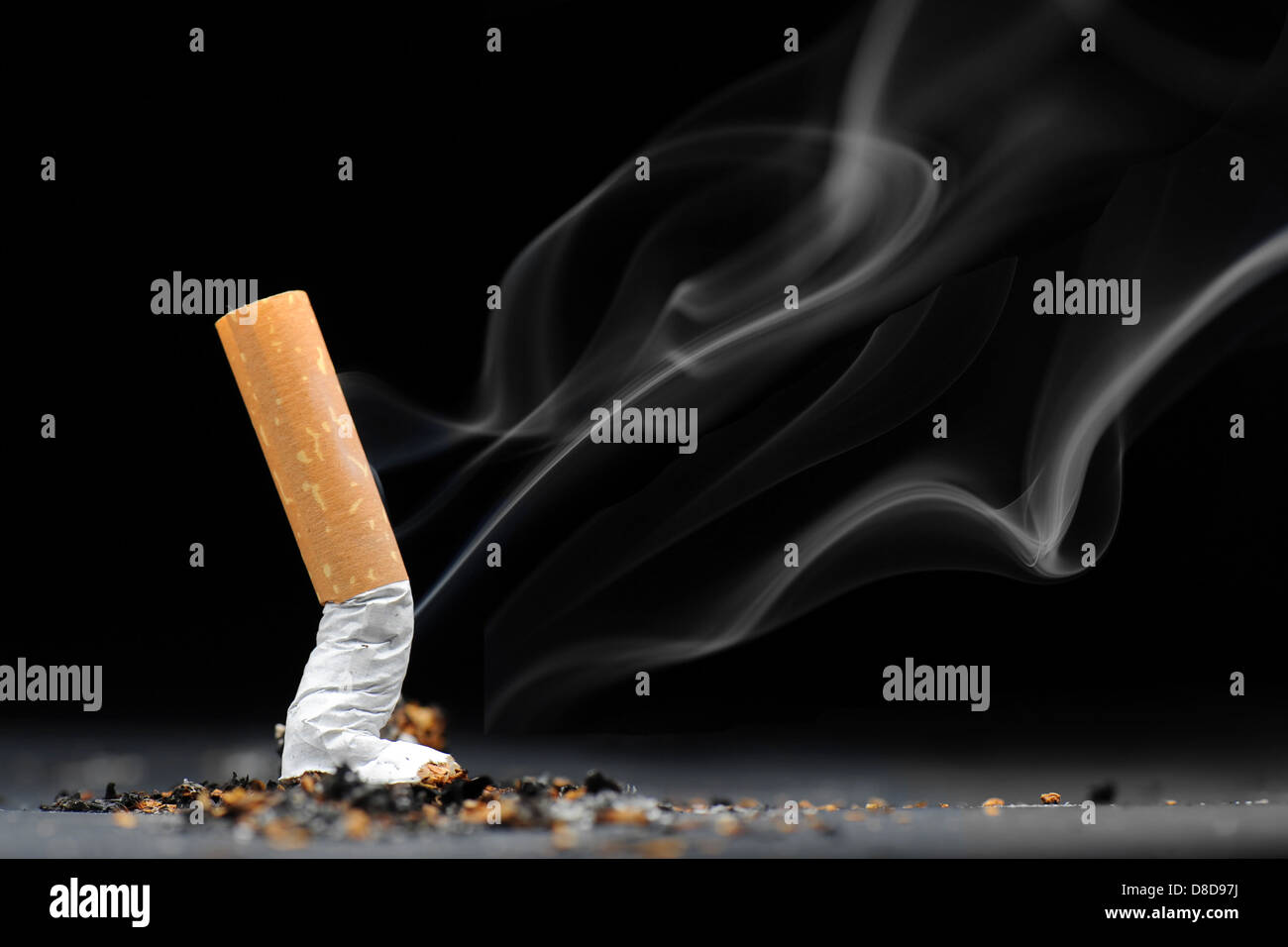 Une cigarette avec de la fumée d'un fond noir. Banque D'Images