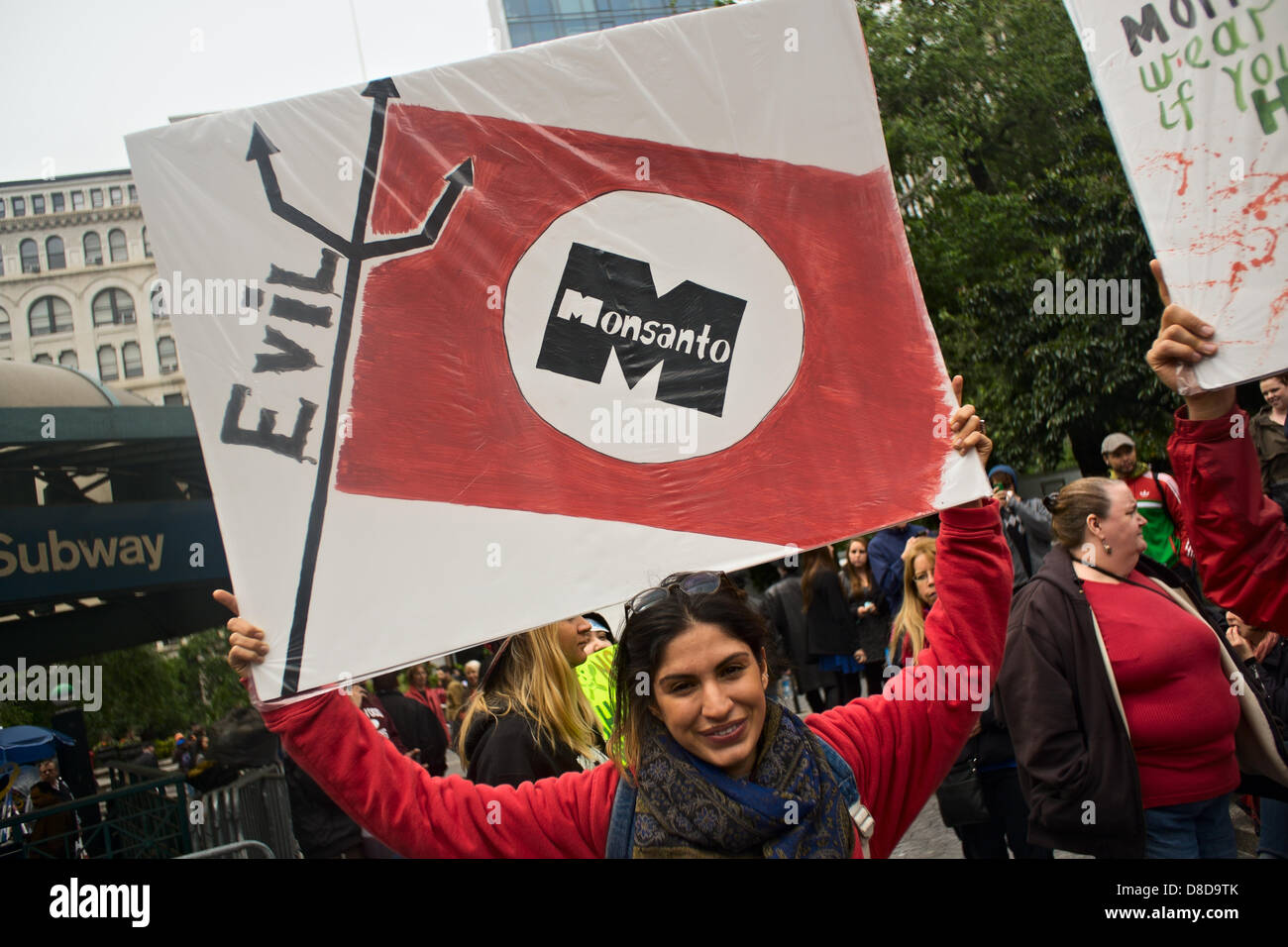 New York, NY, le 25 mai 2013. Une femme est titulaire d'un signe de marque Monsanto comme le mal que les gens à New York's Union Square rassemblement contre l'organisme américain de l'agriculture et de la biotechnologie corporation. Le rassemblement et la marche a été l'un des nombreux aux États-Unis et à des dizaines d'autres pays. Les organisateurs espèrent passer le mot au sujet de ce qu'ils disent sont les effets nocifs des aliments génétiquement modifiés. Banque D'Images