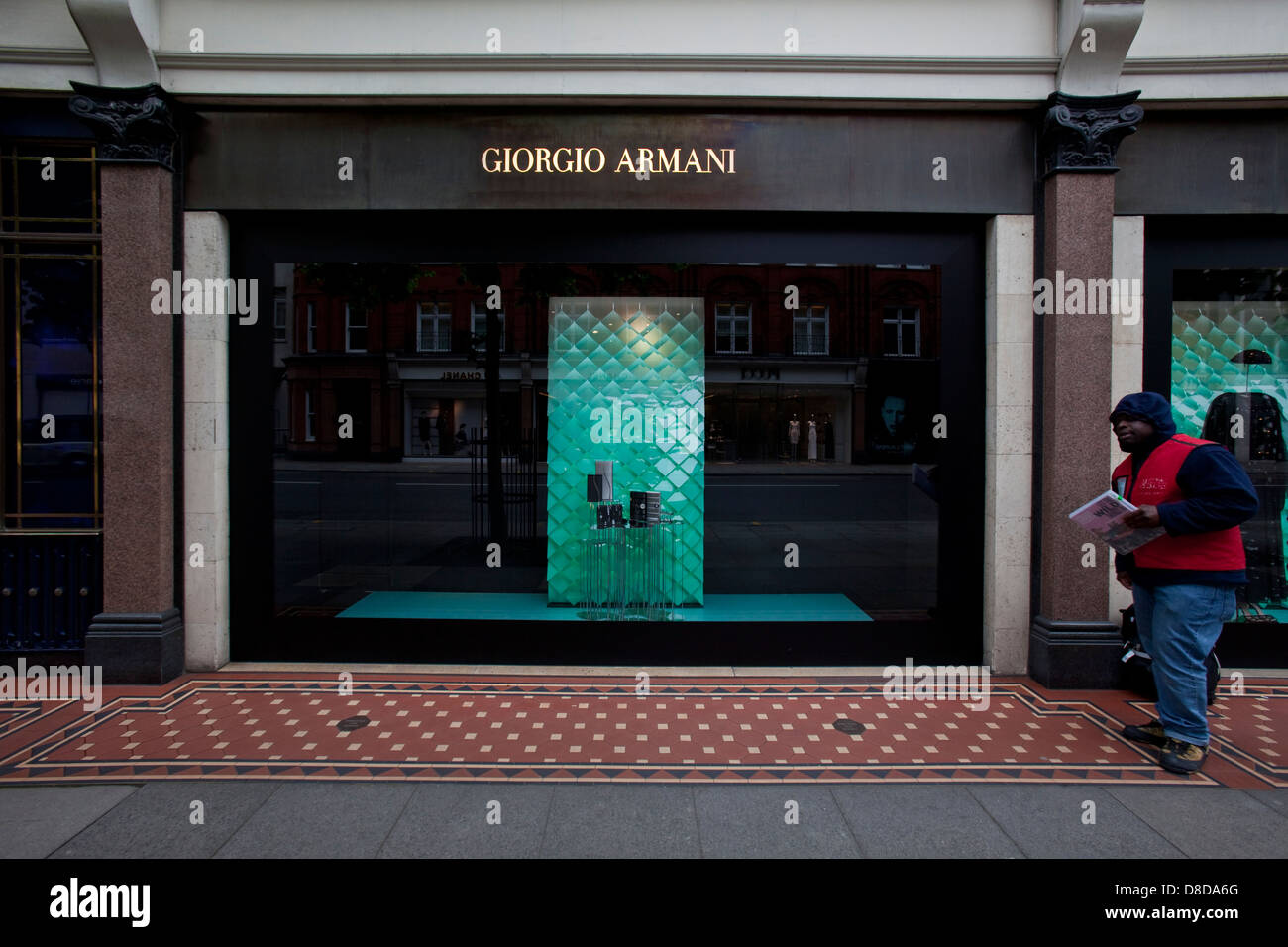 L'homme vend la grande question à l'extérieur de Giorgio Armani Shop, Knightsbridge, Londres, Angleterre Banque D'Images