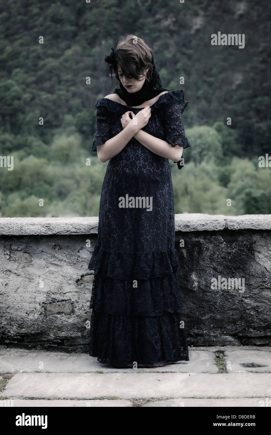 Une femme en deuil avec voile et robe sombre, priant Photo Stock - Alamy