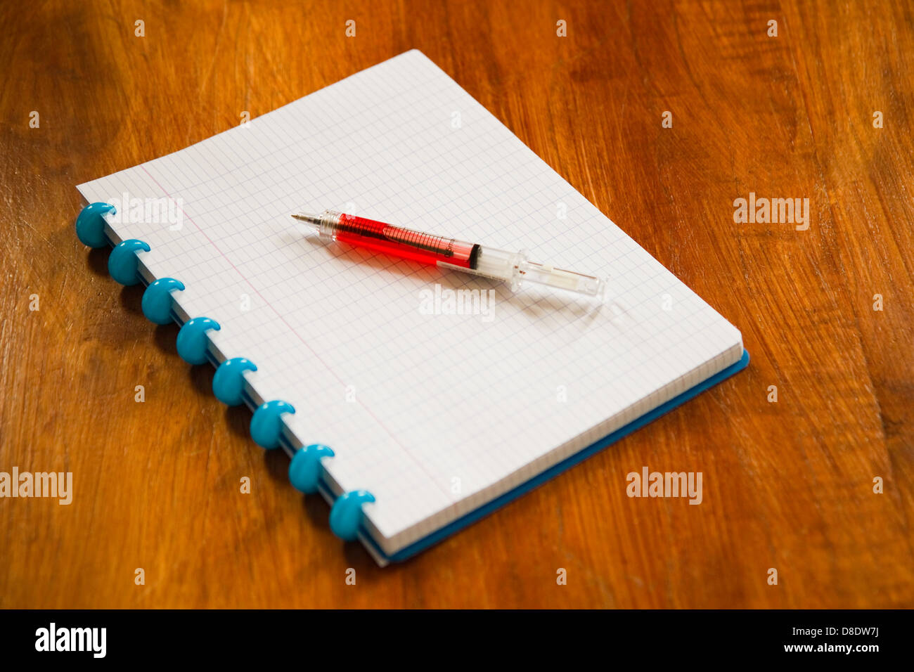 Gribouillis-block et ball-point comme une aiguille sur table en bois Banque D'Images