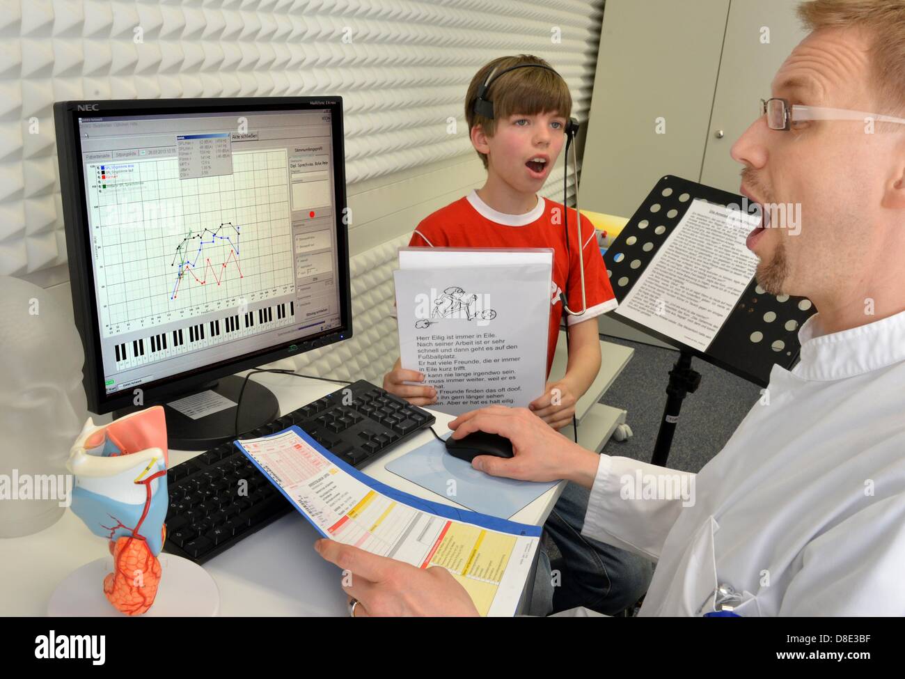 Le professeur Michael Fuchs, directeur du Département pour la voix, de la parole et troubles de l'audition à l'HNO-Klinik de l'Université de Leipzig, mesure le rendement de la voix de 10 ans membre du choeur Thomaner Adam avec un micro et un logiciel informatique à Leipzig, Allemagne, 06 mai 2013. Photo. Waltraud Grubitzsch Banque D'Images