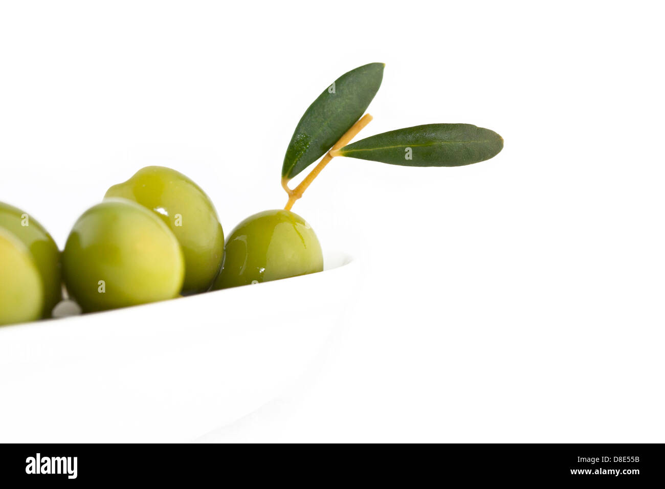 Olives vertes sur fond blanc avec l'exemplaire de l'espace pour votre texte. Se concentrer sur l'olive avec des feuilles. Banque D'Images