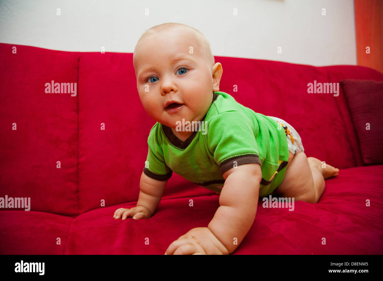 Baby crawling sur canapé rouge Banque D'Images