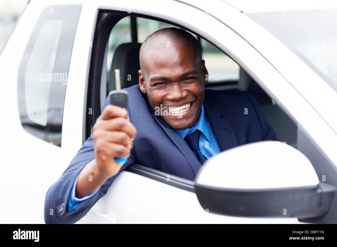 L'Afrique de l'heureux acheteur du véhicule à l'intérieur de sa nouvelle voiture avec clé de voiture Banque D'Images