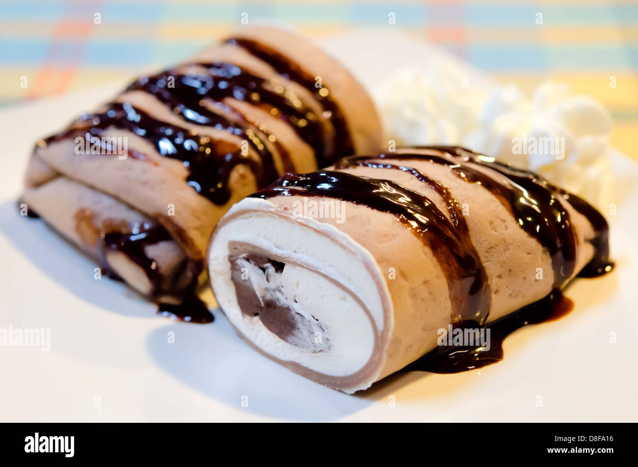 Rouleaux crêpe remplie de crème au chocolat blanc et sirop au chocolat avec garniture , Banque D'Images