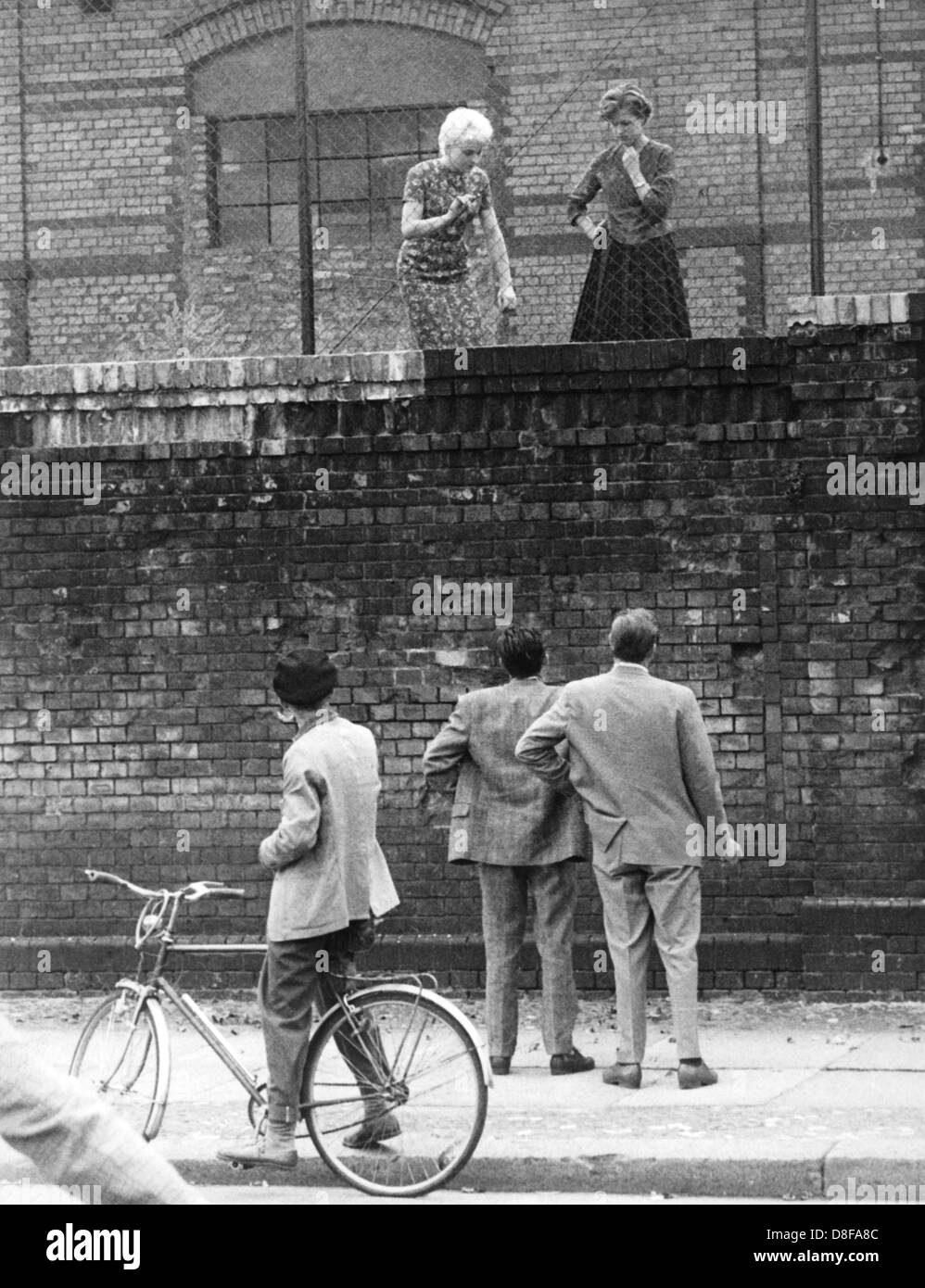 Westberliner Männer am 26.08.1961 sprechen über die Mauer am Stettiner Bahnhof mit ihren Ostberliner Freundinnen. Am frühen Sonntagmorgen des 13. Août 1961 wurde der unter Aufsicht von der DDR Streitkräften bewaffneten mit der Errichtung von Straßensperren Stacheldraht aus dem Bau und einer Mauer begonnen, um den Ostteil Westteil abzusperren Berlins vom. Die Mauer sollte den ständig steigenden von Flüchtlingsstrom- Ost nach Berlin Ouest abschliessen. Foto : Günter Bratke  + + +(c) afp - + + + Banque D'Images